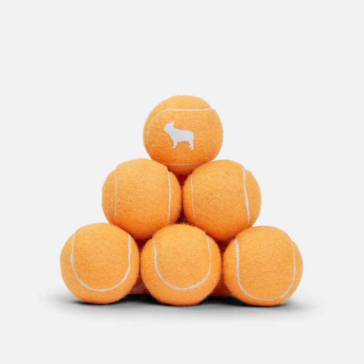 Vibrant Orange Tennis Balls Stacked in Triangular Shape